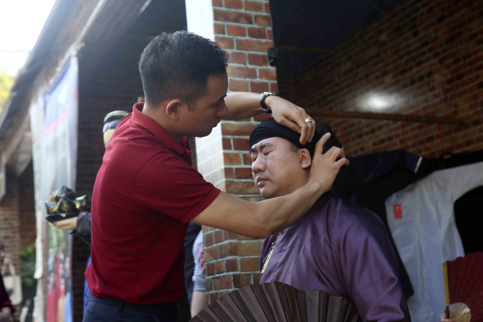 Khách mặc thử đồ truyền thống tại lễ hội. (Ảnh: Tuấn Đức/TTXVN)