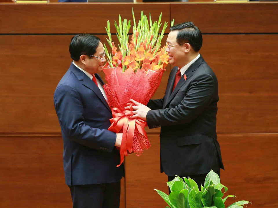 Chủ tịch Quốc hội Vương Đình Huệ tặng hoa chúc mừng Thủ tướng Phạm Minh Chính. (Ảnh: Phương Hoa/TTXVN)