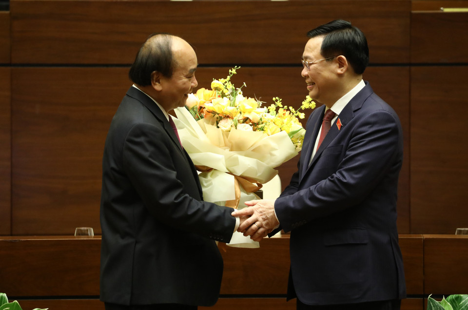 Chủ tịch Quốc hội Vương Đình Huệ chúc mừng Thủ tướng Nguyễn Xuân Phúc hoàn thành xuất sắc nhiệm vụ. (Ảnh: Văn Điệp/TTXVN)