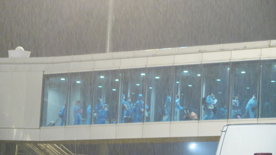 Các công dân Việt Nam mặc đồ bảo hộ, đi theo lối riêng khi máy bay hạ cánh tại Cảng Hàng không quốc tế Cam Ranh.(Ảnh: Phan Sáu/TTXVN)