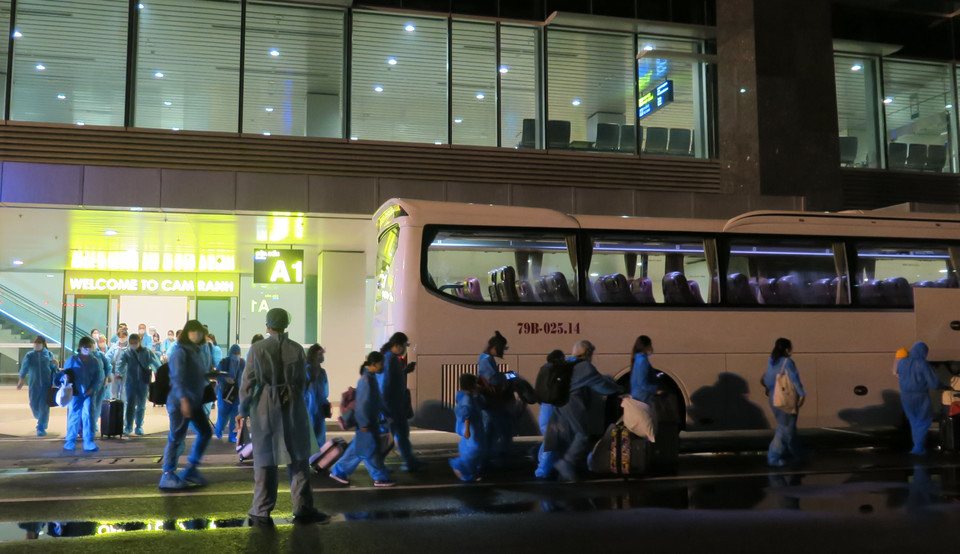 Công dân Việt Nam về nước lên các xe trung chuyển đến điểm cách ly tập trung 14 ngày do quân đội quản lý. (Ảnh: Phan Sáu/TTXVN)