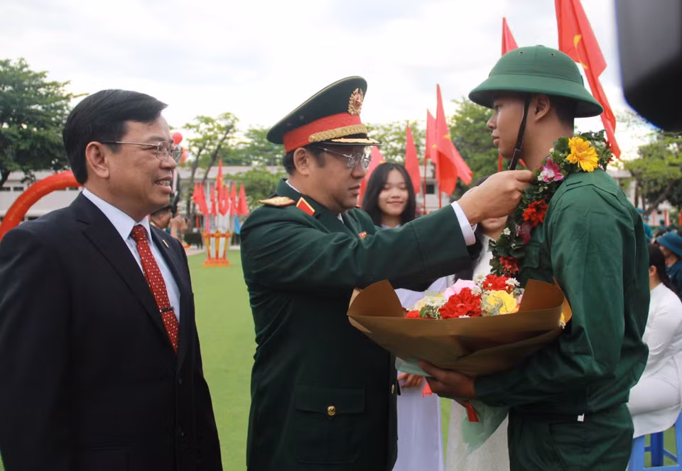 Thượng tướng Phạm Hoài Nam, Ủy viên Trung ương Đảng, Thứ trưởng Bộ Quốc phòng tặng vòng hoa tiễn tân binh lên nhập ngũ ở đơn vị. (Ảnh: Phan Sáu/TTXVN)