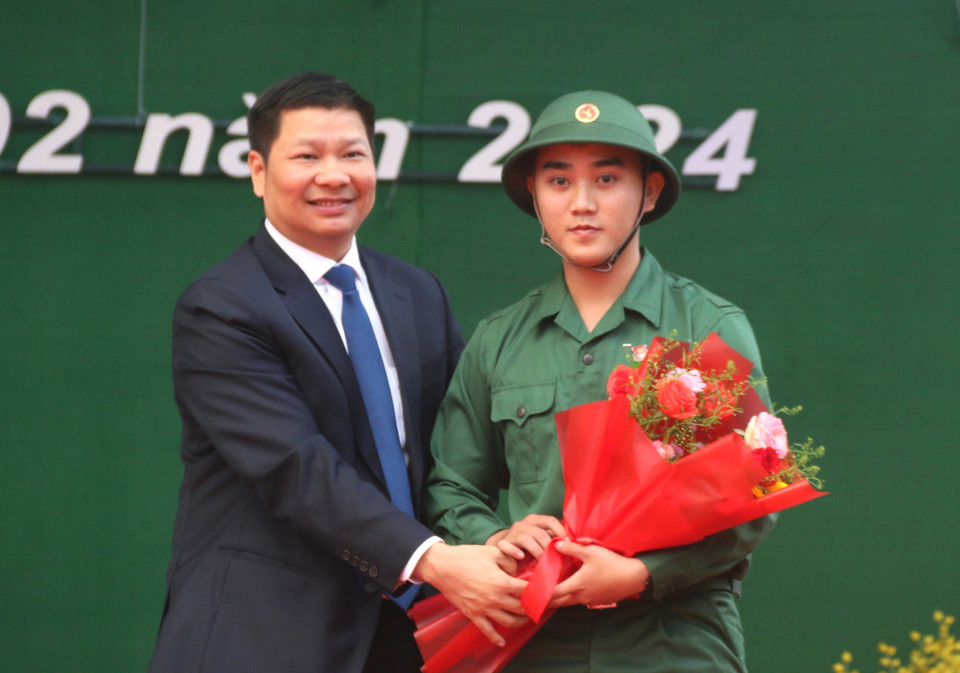 Chủ tịch Ủy ban Nhân dân thành phố Tuy Hòa Cao Đình Huy tặng hoa chúc mừng thanh niên Nguyễn Ngô Khánh Hậu (phường Phú Lâm) lên đường nhập ngũ. (Ảnh: Tường Quân/TTXVN)