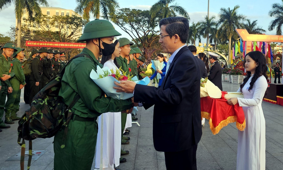 Lãnh đạo thành phố Tam Kỳ (Quảng Nam) tặng hoa, bắt tay, chúc mừng, động viên các tân binh lên đường làm nhiệm vụ. (Ảnh: Trịnh Bang Nhiệm/TTXVN)