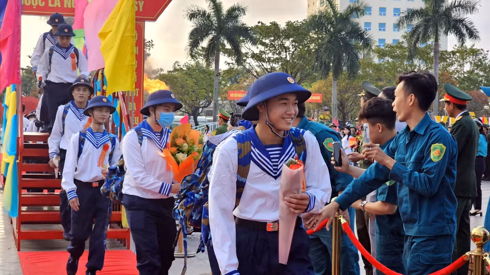 Các tân binh ở Quảng Nam đi qua Cầu vinh quang về đơn vị làm nhiệm vụ. (Ảnh: Trịnh Bang Nhiệm/TTXVN)
