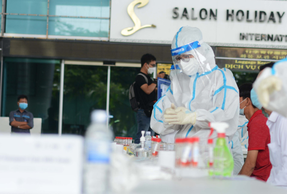 Nhân viên y tế thay gang tay sau mỗi lần lấy mẫu xét nghiệm. (Ảnh: Văn Dũng/TTXVN)