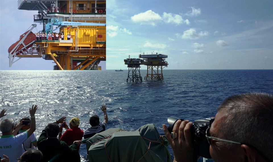 Trước khi kéo ba hồi còi tạm biệt, tàu KN491 đã chạy vòng quanh Nhà giàn để hát vang những bài ca và gửi gắm tình yêu của đất liền tới những người lính biển. Tàu khuất dần, vẫn trông thấy các chiến sĩ Nhà giàn vẫy chào, trên tay họ, lá cờ đỏ Tổ quốc tung bay khẳng định chủ quyền!. (Ảnh: Hùng Võ/Vietnam+)