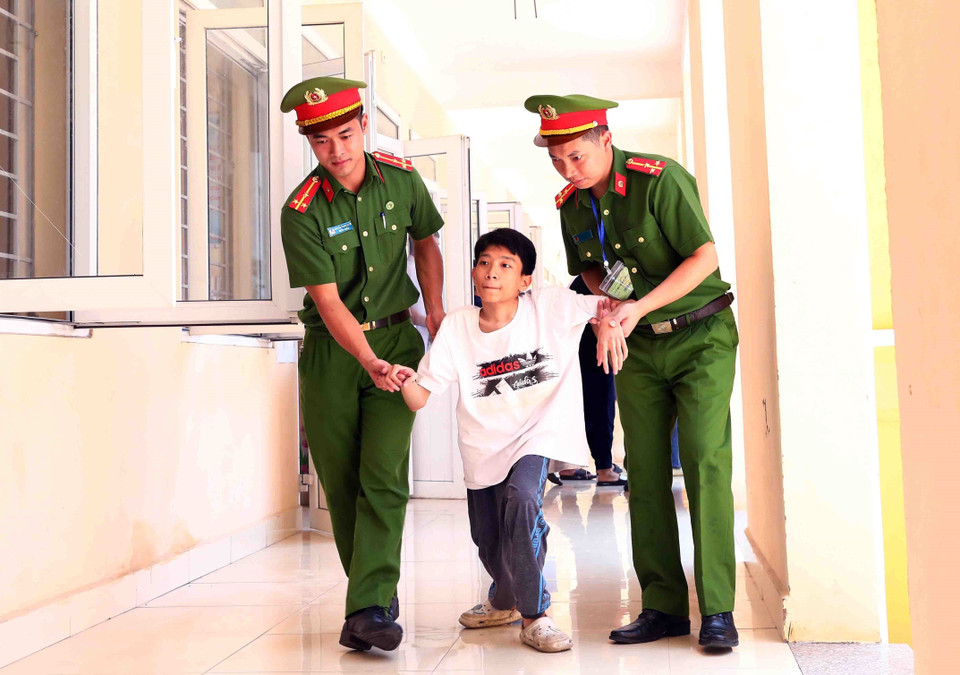 Đoàn viên, thanh niên Công an huyện Thạch Thất giúp đỡ thí sinh Nguyễn Duy Phúc đến điểm thi trường Trung học Cơ sở Hương Ngải. (Ảnh: Phạm Kiên/TTXVN)