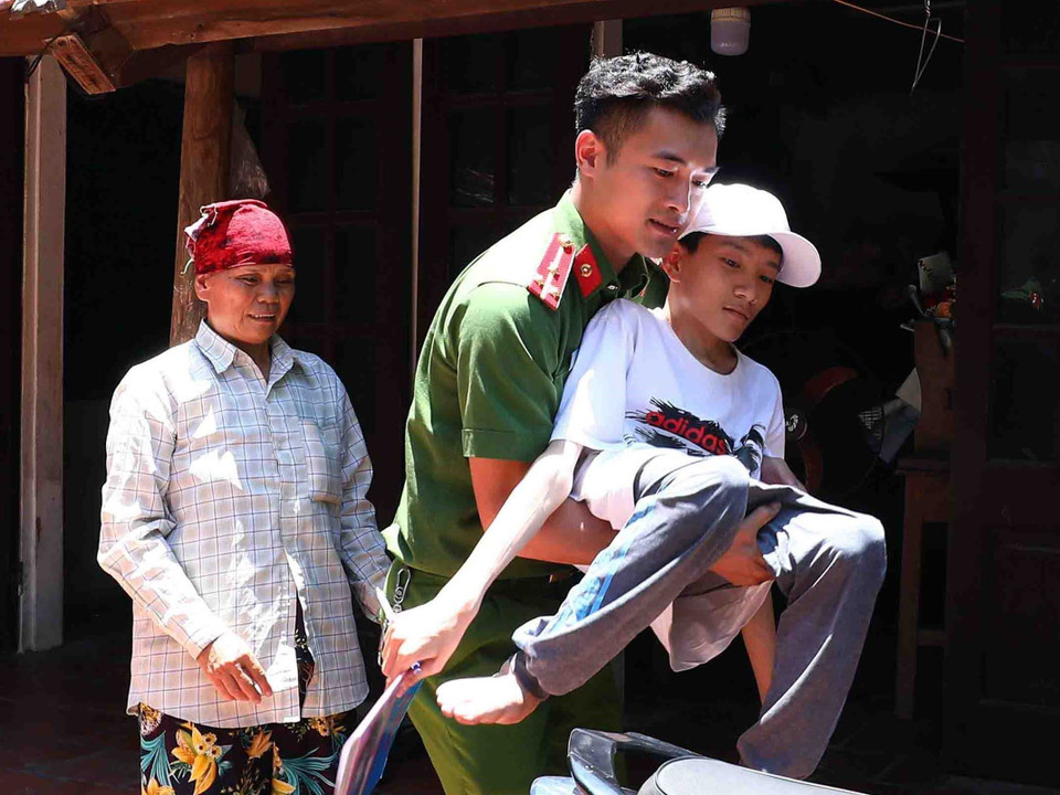 Do Phúc bị khuyết tật bẩm sinh, đi lại khó khăn nên trong những ngày thi, các đoàn viên, thanh niên Công an huyện Thạch Thất đều cử người đến nhà để đưa đón em đến điểm thi. (Ảnh: Phạm Kiên/TTXVN)