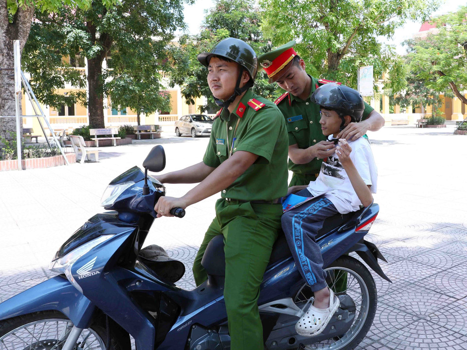 Đoàn viên, thanh niên Công an huyện Thạch Thất đưa thí sinh Nguyễn Duy Phúc tới điểm thi. (Ảnh: Phạm Kiên/TTXVN)