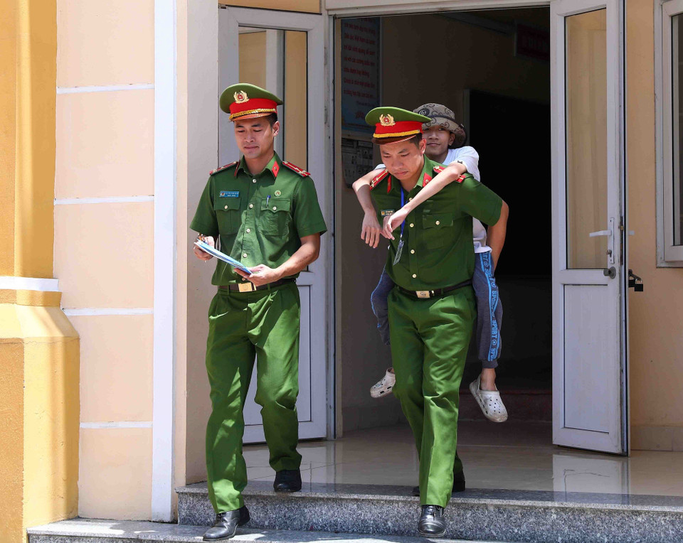 Sau mỗi buổi thi, đoàn viên, thanh niên Công an huyện Thạch Thất lại cõng Phúc từ phòng thi để đưa về nhà. (Ảnh: Phạm Kiên/TTXVN)