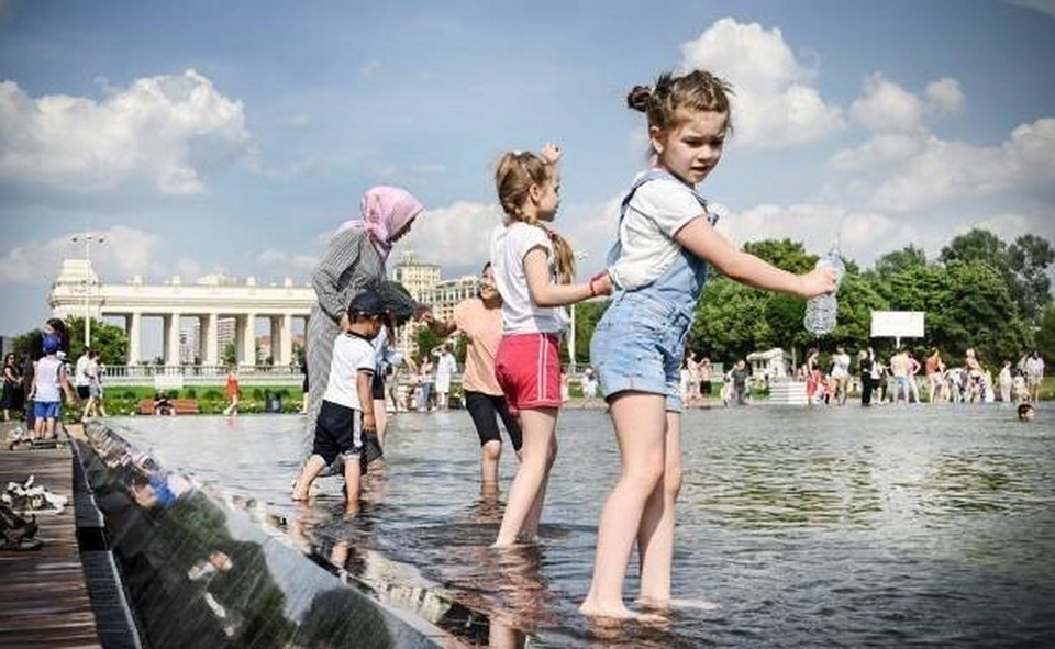 Các em nhỏ tránh nóng bên đài phun nước tại Moskva, Nga. (Ảnh: Getty Images/TTXVN)