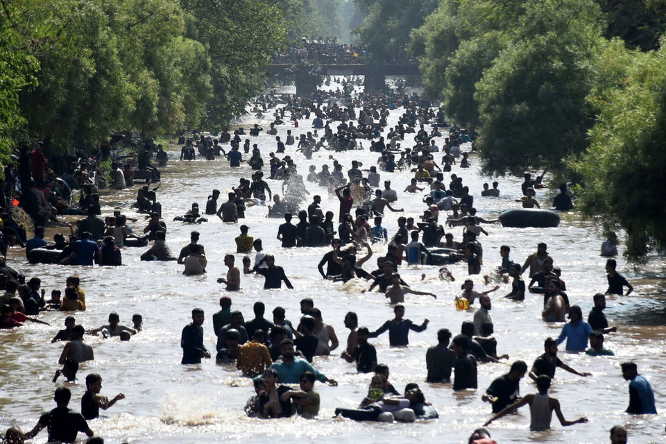 Người dân tắm giải nhiệt trong ngày nắng nóng tại một dòng kênh ở Lahore, Pakistan ngày 2/6/2024. (Ảnh: THX/TTXVN)