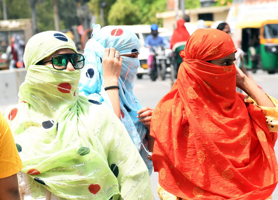 Người dân quấn khăn che mặt để tránh nóng khi di chuyển ngoài trời tại Kanpur, Ấn Độ ngày 18/6/2024. (Ảnh: ANI/TTXVN)