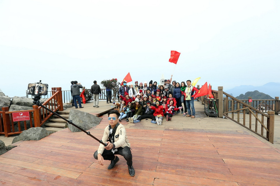 Du khách chụp ảnh lưu niệm trên ​'nóc nhà Đông Dương'. (Ảnh: Huy Hùng/TTXVN)