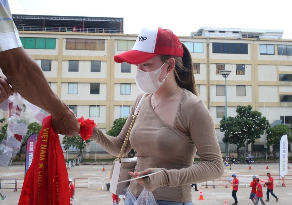 Các cổ động viên Việt Nam trước khi vào sân đều không quên mua chiếc băng rôn quen thuộc để đeo trên trán, cổ vũ cho đội nhà. (Ảnh: Hoàng Linh/TTXVN)