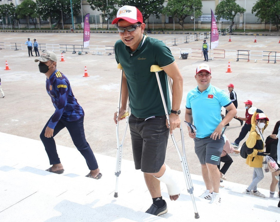 Một cổ động viên bị chấn thương chân nhưng vẫn chống nạng đến sân để cổ vũ cho U22 Việt Nam. (Ảnh: Hoàng Linh/TTXVN)