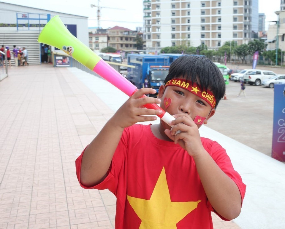 Một cậu bé chuẩn bị sẵn chiếc kèn để mang vào sân cổ vũ cho U22 Việt Nam. (Ảnh: Hoàng Linh/TTXVN)