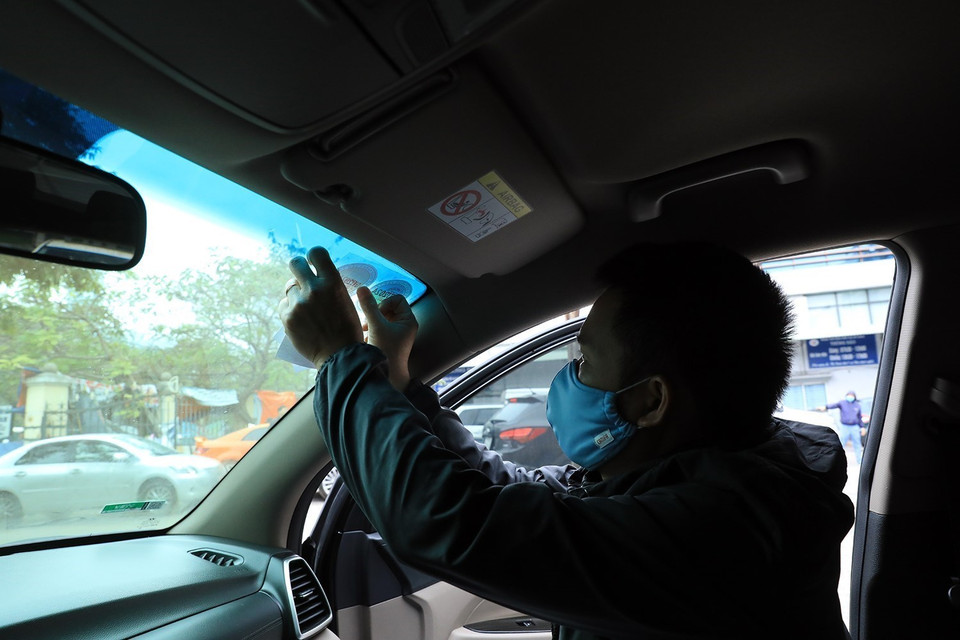 Cán bộ kỹ thuật Trung tâm đăng kiểm xe cơ giới sô 29.03V dán tem đăng kiểm đối với các xe đã kiểm tra. (Ảnh: Tuấn Anh/TTXVN)