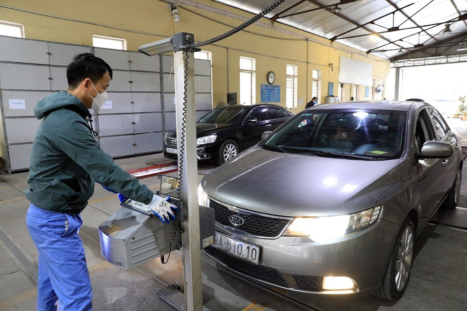 Cán bộ Trung tâm đăng kiểm xe cơ giới số 29.03V kiểm tra độ chiếu sáng của phương tiện. (Ảnh: Tuấn Anh/TTXVN)