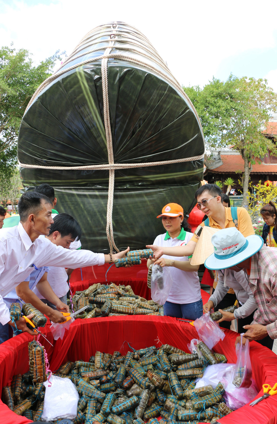 Ngay sau khi thực hiện nghi thức công bố và cắt đòn bánh tét lớn, toàn bộ 2020 đòn bánh tét nhỏ được gửi tặng cho nhân dân ăn Tết. (Ảnh: Chương Đài/TTXVN)