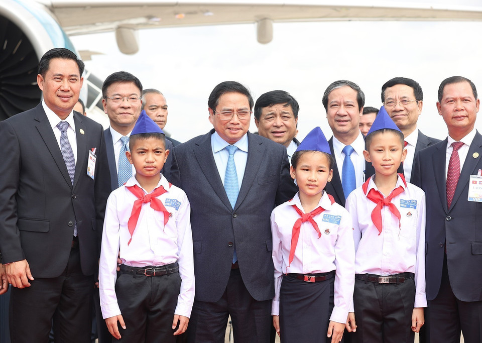  Thủ tướng Phạm Minh Chính chụp ảnh với các cháu thiếu nhi tại lễ tiễn tại sân bay Quốc tế Wattay, thủ đô Vientiane. (Ảnh: Dương Giang/TTXVN)