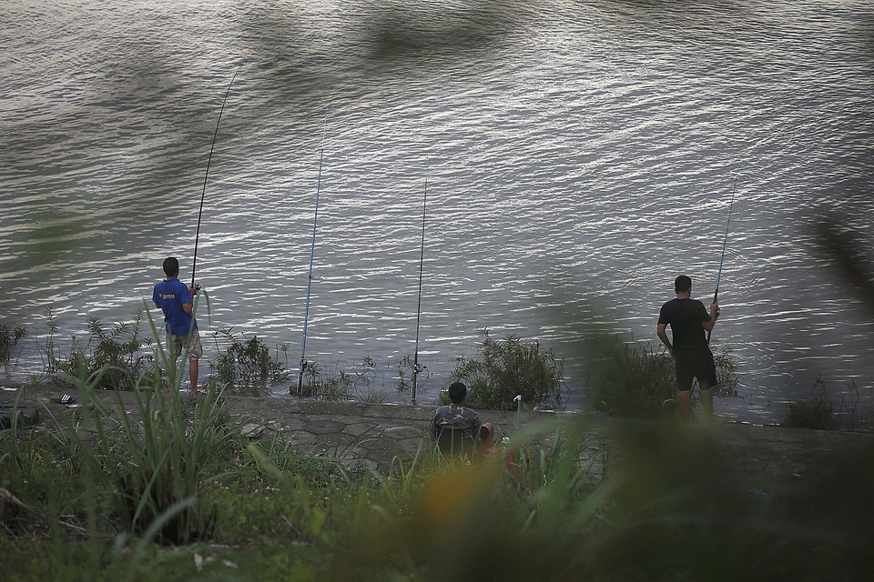 Người dân câu cá ngay phía chân đập thủy điện. (Ảnh: Trọng Đạt/TTXVN)