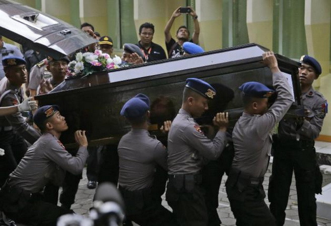 Cảnh sát Indonesia khiêng quan tài của Hayati Lutfiah, một nạn nhân trên chuyến bay QZ8501 trả về cho gia đình