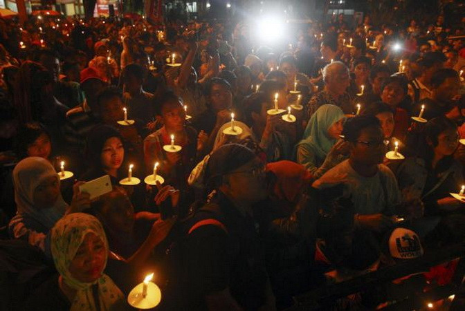 Người dân Indonesia thắp nến cầu nguyện cho các nạn nhân trên chuyến bay QZ8501 ở Surabaya. (Nguồn: Getty Images)