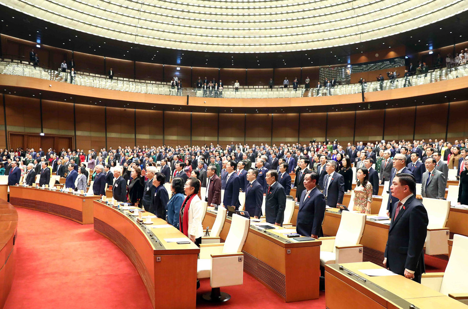 Các đồng chí lãnh đạo, nguyên lãnh đạo Đảng, Nhà nước và đại biểu Quốc hội thực hiện nghi lễ chào cờ. (Ảnh: Phạm Kiên/TTXVN)
