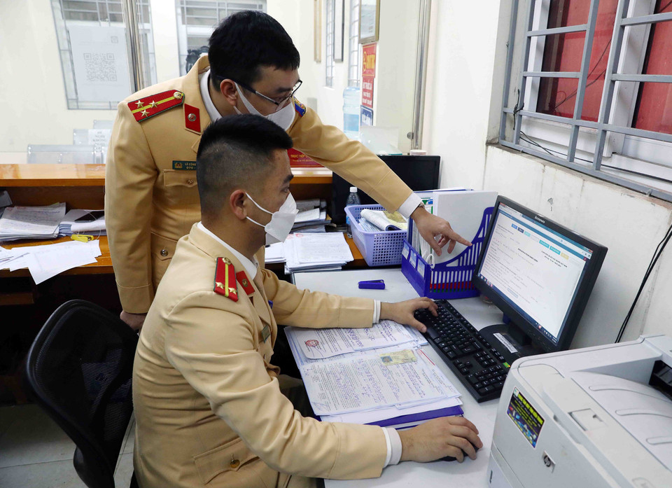 Cán bộ, chiến sỹ Đội Cảnh sát giao thông số 15 nhập biên bản vi phạm hành chính vào hệ thống phần mềm xử lý vi phạm. (Ảnh: Phạm Kiên/TTXVN)
