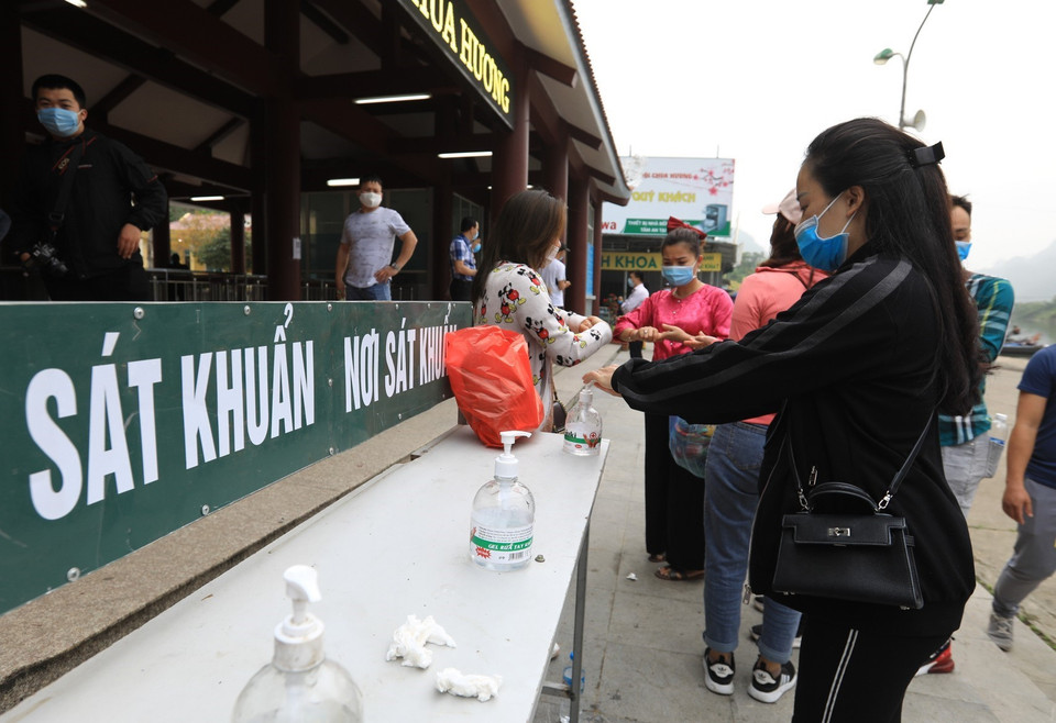 Trước cửa vào ga cáp treo chùa Hương được bố trí biển hướng dẫn quét mã QR-code để khai báo y tế và dung dịch rửa tay sát khuẩn cho du khách. (Ảnh: Thành Đạt/TTXVN) 