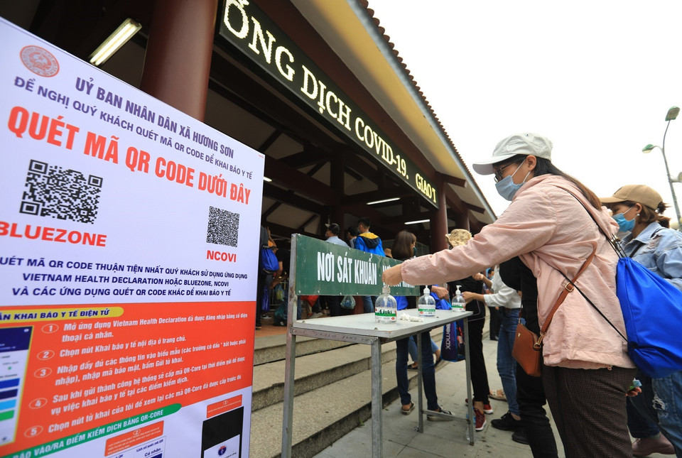 Trước cửa vào ga cáp treo chùa Hương được bố trí biển hướng dẫn quét mã QR-code để khai báo y tế và dung dịch rửa tay sát khuẩn cho du khách. (Ảnh: Thành Đạt/TTXVN)