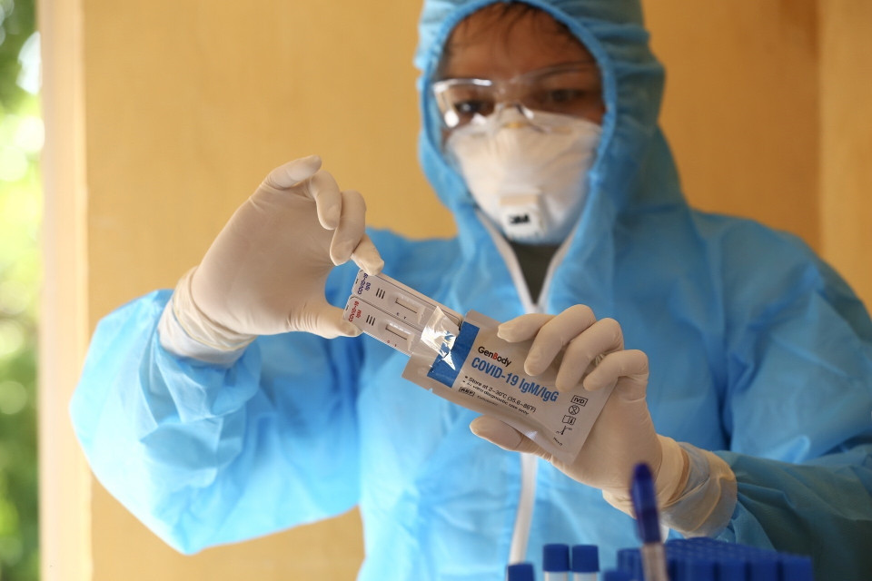 Nhân viên y tế chuẩn bị bộ kit xét nghiệm nhanh SARS-CoV-2 cho người dân tại xã Mai Đình, huyện Sóc Sơn. (Ảnh: Minh Quyết/TTXVN)