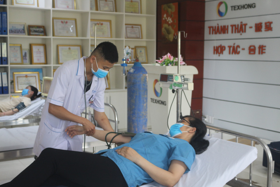 Công nhân sau khi tiêm có biểu hiện mệt sẽ được cán bộ Y tế kiểm tra huyết áp, nhịp tim. (Ảnh: Thanh Vân/TTXVN)