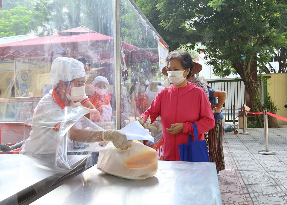 Người mua và người bán ngăn cách bởi vách ngăn giúp hạn chế tiếp xúc, giữ an toàn trong tình hình dịch bệnh vẫn diễn biến phức tạp. (Ảnh: Hoàng Hiếu/TTXVN)