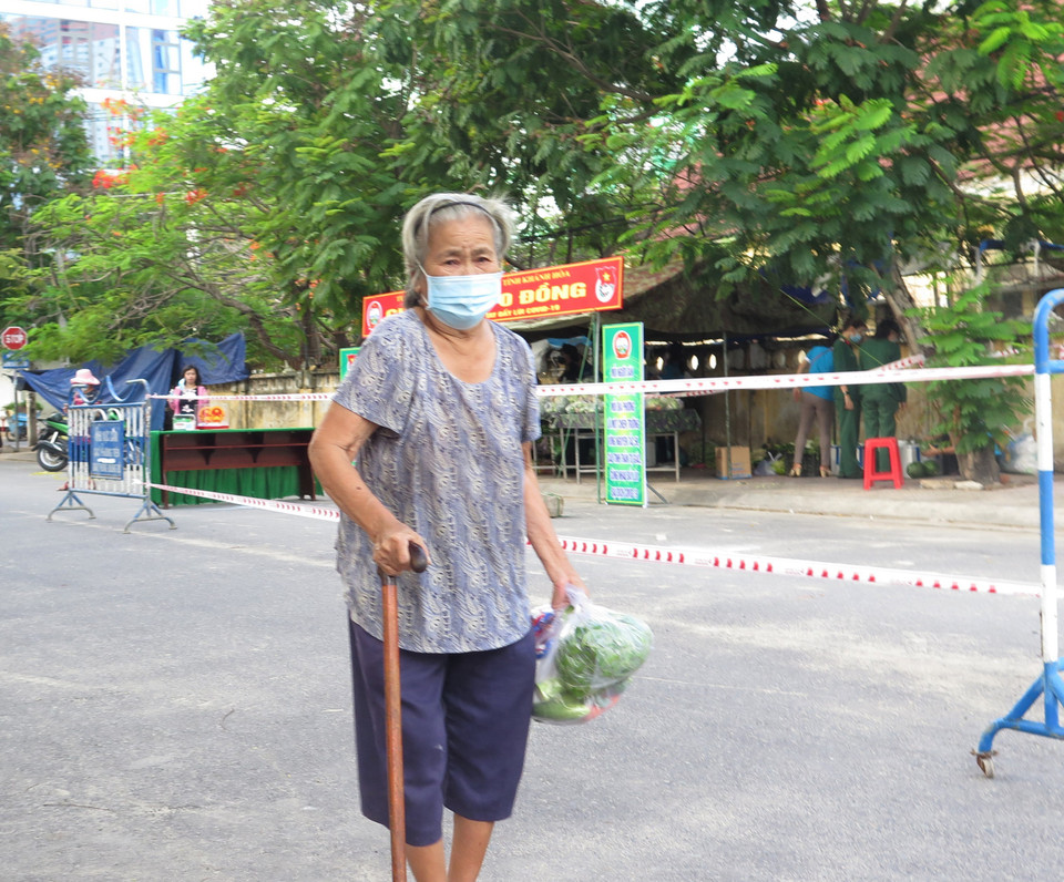 Bà Nguyễn Thị Cúc, người dân phường Vĩnh Phước, thành phố Nha Trang, tỉnh Khánh Hòa, nhận thực phẩm từ gian hàng 0 đồng do Bộ Chỉ huy Quân sự tỉnh Khánh Hòa tổ chức. (Ảnh: Phan Sáu/TTXVN)