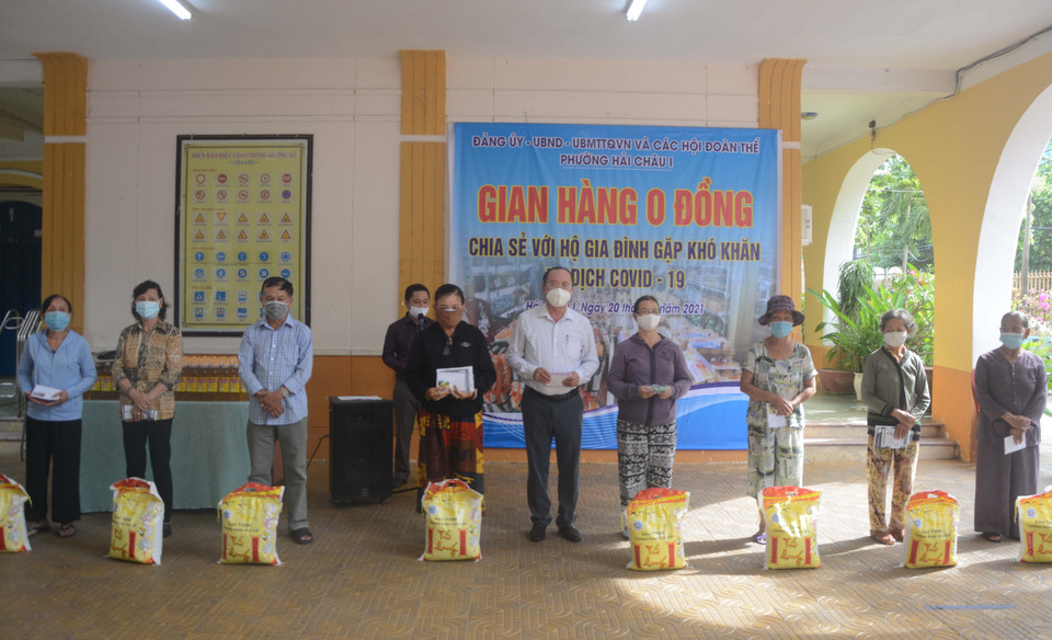 Lãnh đạo phường Hải Châu 1 (quận Hải Châu, thành phố Đà Nẵng) trao quà cho các hộ gia đình khó khăn bị ảnh hưởng bởi dịch COVID-19. (Ảnh: Văn Dũng/TTXVN)