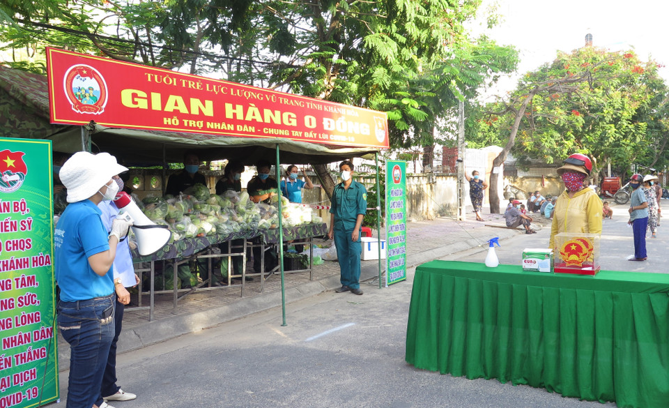 Người dân đến nhận hỗ trợ từ gian hàng 0 đồng sẽ được sát khuẩn, giữ khoảng cách theo quy định 5K của Bộ Y tế. (Ảnh: Phan Sáu/TTXVN)