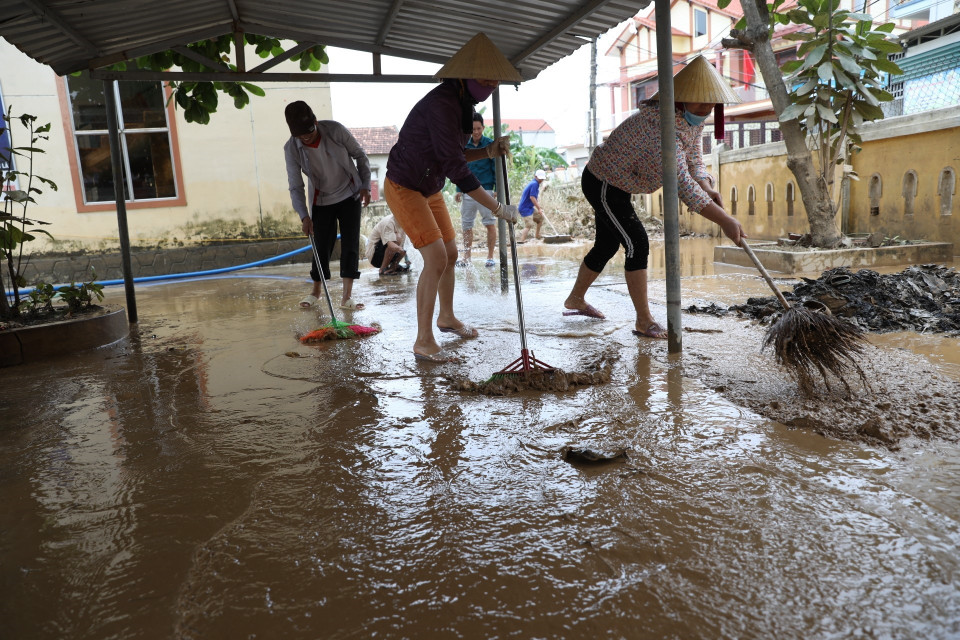 Người dân huyện Lệ Thủy dọn dẹp nhà cửa. (Ảnh: Danh Lam/TTXVN)
