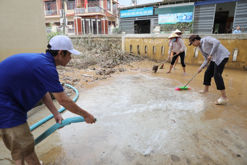 Người dân huyện Lệ Thủy dọn dẹp nhà cửa. (Ảnh: Danh Lam/TTXVN)