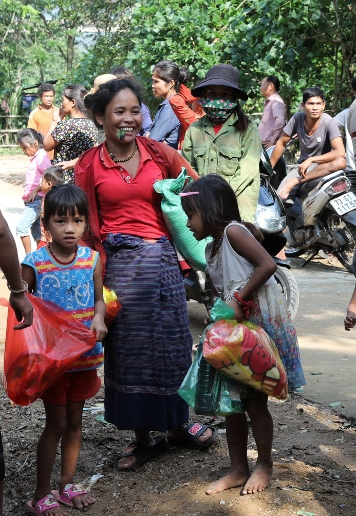 Từ người già tới trẻ em, ai cũng tay xách nách mang những món quà hỗ trợ đầy ý nghĩa. (Ảnh: Danh Lam/TTXVN)