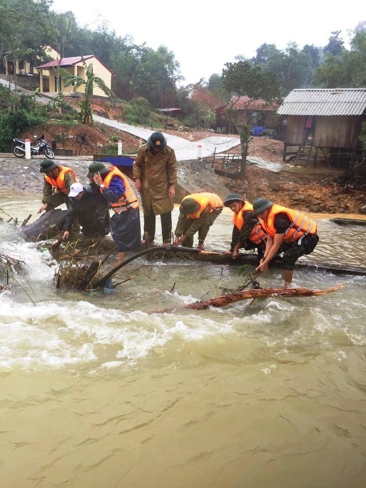 Cán bộ, chiến sỹ Đồn Biên phòng Làng Ho giúp dân huyện Lệ Thuỷ ứng phó với mưa lũ. (Ảnh: Hồ Cầu/TTXVN)