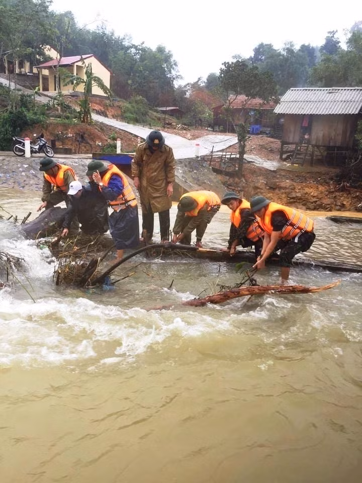 Cán bộ, chiến sỹ Đồn Biên phòng Làng Ho giúp dân huyện Lệ Thuỷ ứng phó với mưa lũ. (Ảnh: Hồ Cầu/TTXVN)