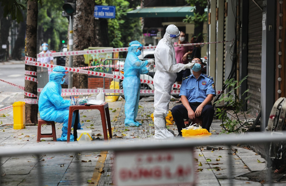 Nhân viên y tế quận Hai Bà Trưng lấy mẫu xét nghiệm SARS-CoV-2 cho người dân từ số nhà 260 đến 266 phố Bà Triệu. (Ảnh: Thành Đạt/TTXVN)