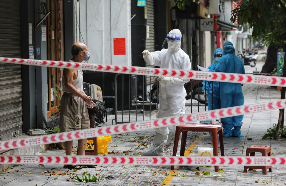 Nhân viên y tế quận Hai Bà Trưng gọi người dân các hộ gia đình xung quanh số nhà 264 phố Bà Triệu ra lấy mẫu xét nghiệm COVID-19. (Ảnh: Thành Đạt/TTXVN)