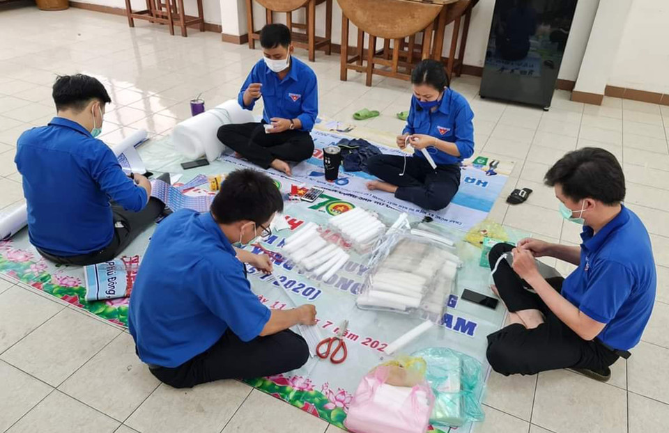 Đoàn viên thanh niên Tỉnh đoàn Tiền Giang làm mũ bảo hộ để tặng các điểm cách ly và các chốt kiểm dịch. (Ảnh: Hữu Chí/TTXVN)