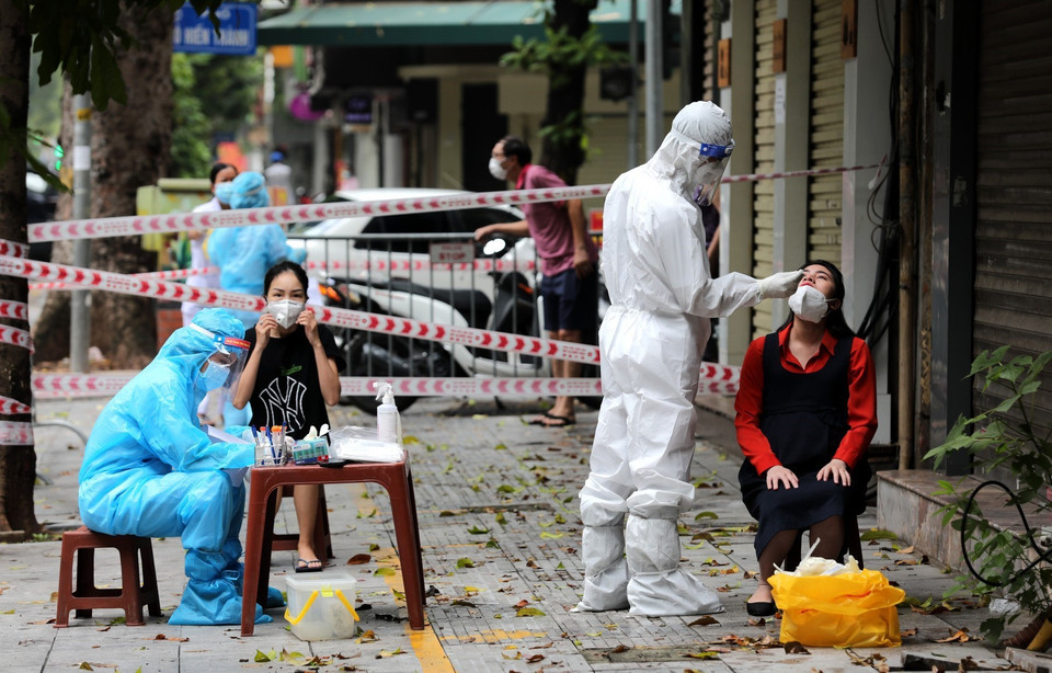 Người dân từ số nhà 260 đến 266 phố Bà Triệu được lấy mẫu xét nghiệm COVID-19 ngay sáng 12/8 khi có thông tin 2 ca dương tính với SARS-CoV-2. (Ảnh: Thành Đạt/TTXVN)