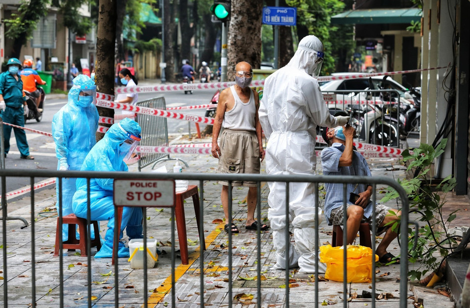 Nhân viên y tế quận Hai Bà Trưng lấy mẫu xét nghiệm SARS-CoV-2 cho người dân từ số nhà 260 đến 266 phố Bà Triệu. (Ảnh: Thành Đạt/TTXVN)