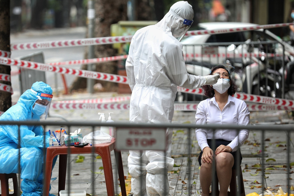 Nhân viên y tế quận Hai Bà Trưng lấy mẫu xét nghiệm SARS-CoV-2 cho người dân từ số nhà 260 đến 266 phố Bà Triệu. (Ảnh: Thành Đạt/TTXVN)